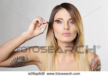 Stock Photo - Woman applying mascara. Fotosearch