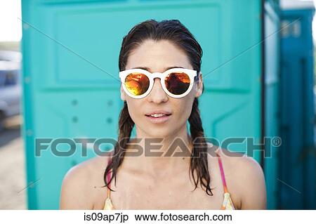 Stock Photography - Woman by changing room on beach. Fotosearch