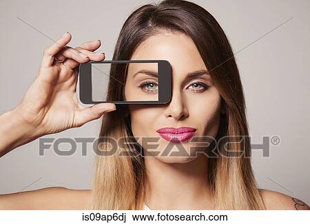 Woman holding up frame to eye View Large Photo Image Stock Image - Woman holding up frame to eye. Fotosearch