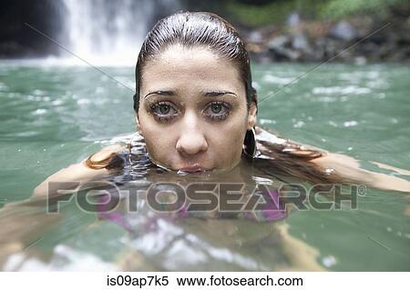 Stock Photography - "Woman swimming, waterfall in background". Fotosearch