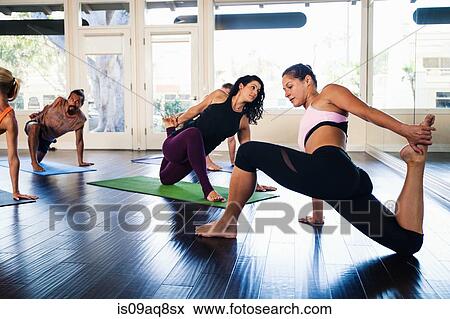 Stock Photo - Yoga instructor demonstrating yoga position in class. Fotosearch