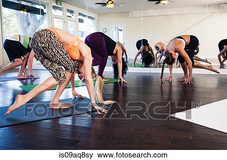 Yoga instructor demonstrating yoga position in class View Large Photo Image Stock Photo - Yoga instructor demonstrating yoga position in class. Fotosearch