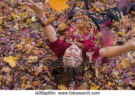 Young boy playing in autumn leaves View Large Photo Image Stock Photo - Young boy playing in autumn leaves. Fotosearch