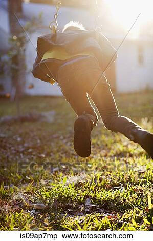 Young boy playing on garden swing View Large Photo Image Stock Photography - Young boy playing on garden swing. Fotosearch