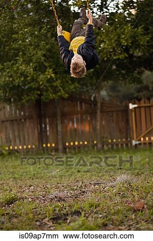Young boy swinging high on garden swing View Large Photo Image Picture - Young boy swinging high on garden swing. Fotosearch