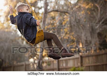 Young boy swinging high on garden swing View Large Photo Image Stock Photography - Young boy swinging high on garden swing. Fotosearch