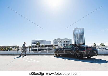 Young businessman on city rooftop car park walking and talking on smartphone View Large Photo Image Stock Image - Young businessman on city rooftop car park walking and talking on smartphone. Fotosearch
