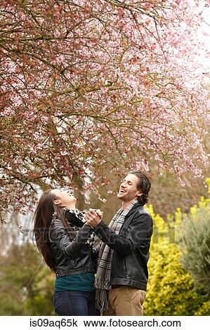 Young couple dancing under blossom in park View Large Photo Image Stock Image - Young couple dancing under blossom in park. Fotosearch