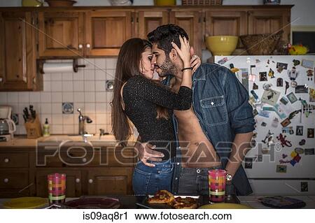 Young couple hugging in kitchen View Large Photo Image Stock Image - Young couple hugging in kitchen. Fotosearch