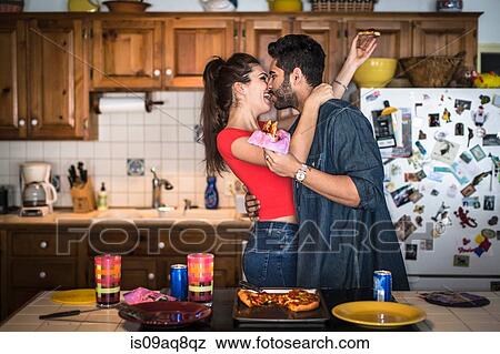 Young couple hugging in kitchen View Large Photo Image Stock Photo - Young couple hugging in kitchen. Fotosearch