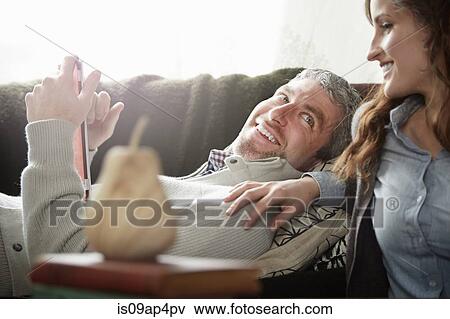 Stock Photo - Young couple in sitting room browsing digital tablet. Fotosearch