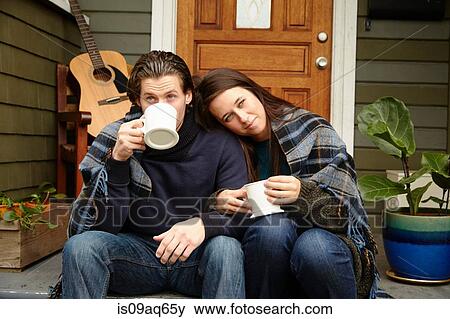 Young couple on porch step wrapped in blanket drinking coffee View Large Photo Image Stock Photo - Young couple on porch step wrapped in blanket drinking coffee. Fotosearch