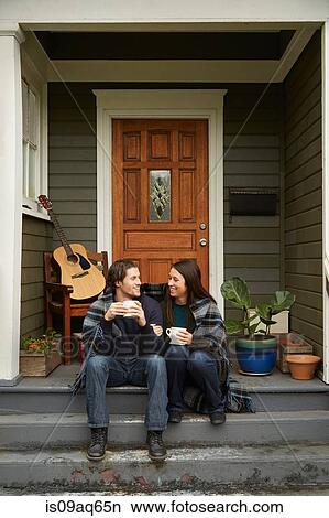 Young couple sitting on porch step chatting View Large Photo Image Picture - Young couple sitting on porch step chatting. Fotosearch