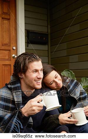 Young couple sitting on porch step wrapped in blanket View Large Photo Image Stock Photo - Young couple sitting on porch step wrapped in blanket. Fotosearch