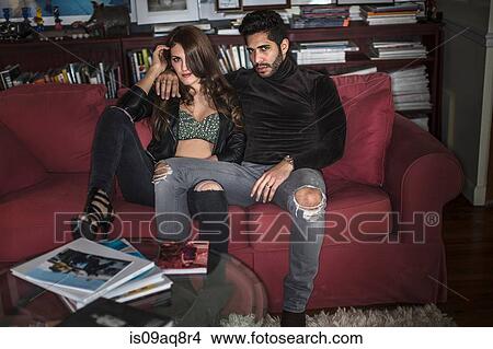Picture - Young couple sitting on sofa. Fotosearch