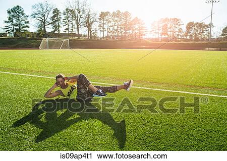 Young female athlete doing sit ups on sports field View Large Photo Image Stock Image - Young female athlete doing sit ups on sports field. Fotosearch