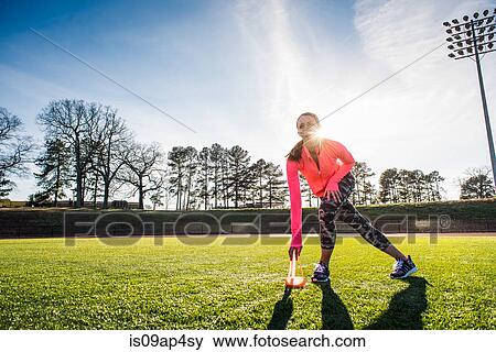 Stock Photo - Young female athlete training on sports field. Fotosearch