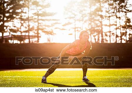 Young female athlete warming up on sports field View Large Photo Image Stock Photograph - Young female athlete warming up on sports field. Fotosearch