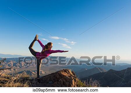 Picture - "Young female trail runner in yoga pose on rock, Pacific Crest Trail, Pine Valley, California, USA". Fotosearch