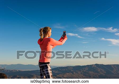 "Young female trail runner photographing view on smartphone, Pacific Crest Trail, Pine Valley, California, USA" View Large Photo Image Stock Photography - "Young female trail runner photographing view on smartphone, Pacific Crest Trail, Pine Valley, California, USA". Fotosearch