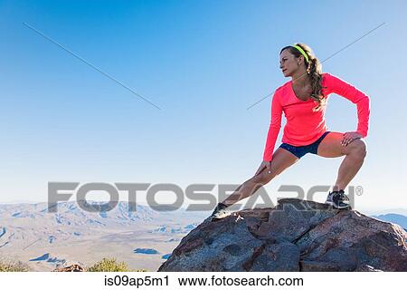 "Young female trail runner stretching on rock on Pacific Crest Trail, Pine Valley, California, USA" View Large Photo Image Stock Image - "Young female trail runner stretching on rock on Pacific Crest Trail, Pine Valley, California, USA". Fotosearch