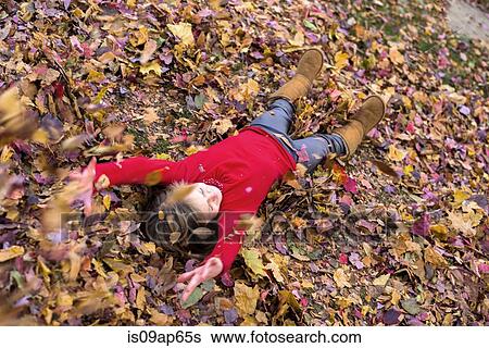 Young girl playing in autumn leaves View Large Photo Image Stock Photograph - Young girl playing in autumn leaves. Fotosearch