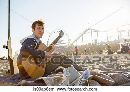 "Young man playing guitar, Santa Monica Pier, Santa Monica Beach, US" View Large Photo Image Picture - "Young man playing guitar, Santa Monica Pier, Santa Monica Beach, US". Fotosearch