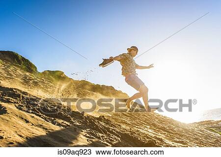 Young man running down sandy hill View Large Photo Image Stock Image - Young man running down sandy hill. Fotosearch