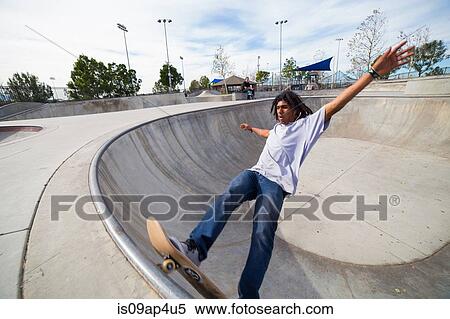 Young man skateboarding up skateboard park wall View Large Photo Image Stock Photography - Young man skateboarding up skateboard park wall. Fotosearch