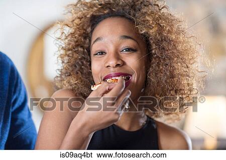 Young woman eating party food in kitchen View Large Photo Image Stock Photograph - Young woman eating party food in kitchen. Fotosearch