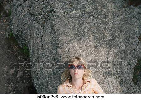 "Young woman in sunglasses, lying on rock" View Large Photo Image Stock Photograph - "Young woman in sunglasses, lying on rock". Fotosearch