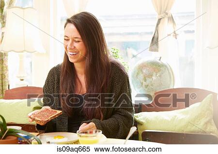 Young woman laughing at breakfast table View Large Photo Image Stock Photography - Young woman laughing at breakfast table. Fotosearch