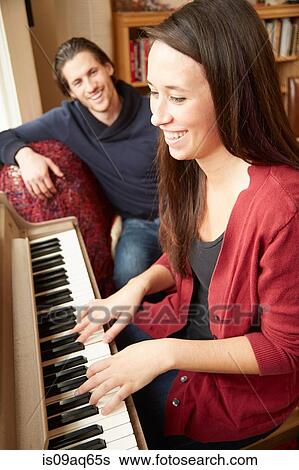 Young woman playing the piano for boyfriend View Large Photo Image Stock Photograph - Young woman playing the piano for boyfriend. Fotosearch