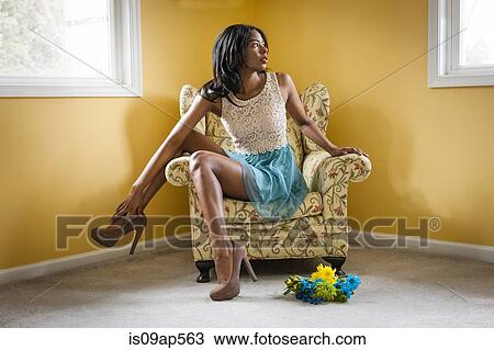 Stock Image - Young woman posing in armchair. Fotosearch