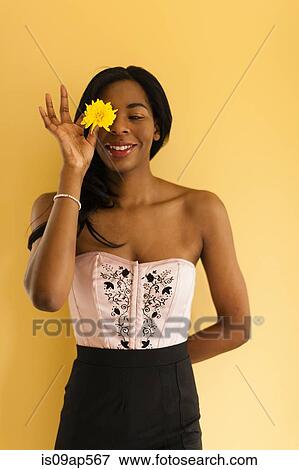 Stock Photo - Young woman posing with flower. Fotosearch