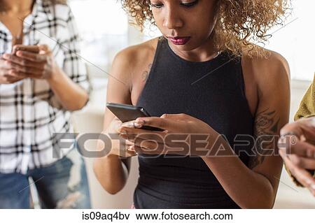 Young woman reading smartphone text in kitchen View Large Photo Image Stock Photo - Young woman reading smartphone text in kitchen. Fotosearch