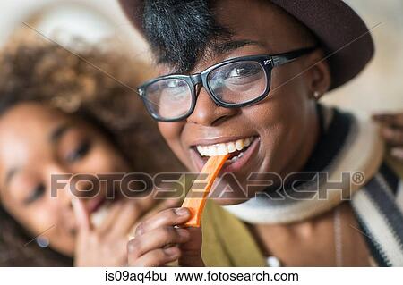 Young women eating party food in kitchen View Large Photo Image Stock Photograph - Young women eating party food in kitchen. Fotosearch