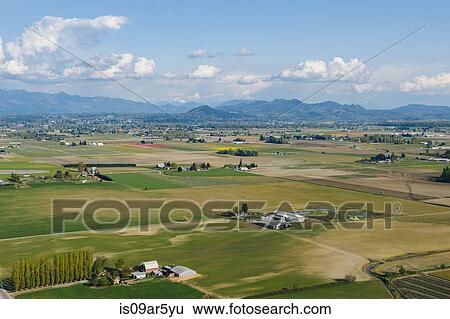 Aerial view of valley fields and distant mountains View Large Photo Image Stock Photograph - Aerial view of valley fields and distant mountains. Fotosearch