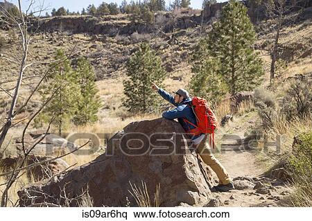 Stock Photography - "Backpacker pointing up, Smith Rock State Park, Oregon". Fotosearch