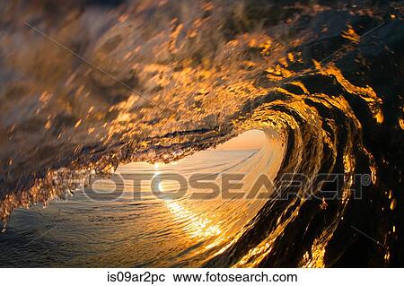 Stock Image - "Barrelling wave, sunset, Hawaii, USA". Fotosearch