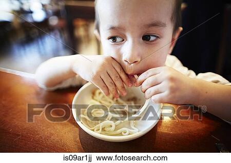 Boy eating noodles in restaurant View Large Photo Image Stock Image - Boy eating noodles in restaurant. Fotosearch