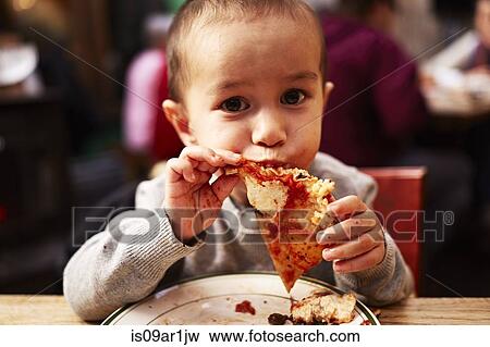 Boy eating pizza in restaurant View Large Photo Image Stock Photo - Boy eating pizza in restaurant. Fotosearch