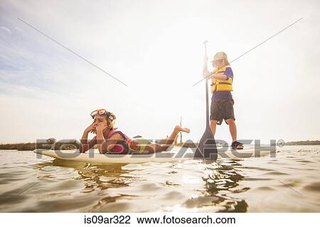 "Boy standup paddleboarding with sister in the sound, Fort Walton, Florida, USA" View Large Photo Image Stock Image - "Boy standup paddleboarding with sister in the sound, Fort Walton, Florida, USA". Fotosearch