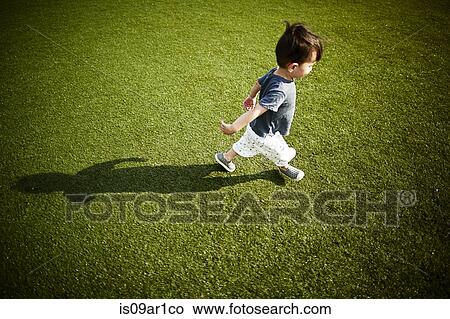 Boy with shadow running across the grass View Large Photo Image Picture - Boy with shadow running across the grass. Fotosearch