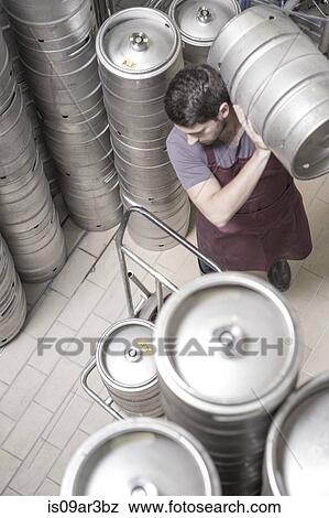 Brewer moving kegs in brewery View Large Photo Image Stock Photo - Brewer moving kegs in brewery. Fotosearch