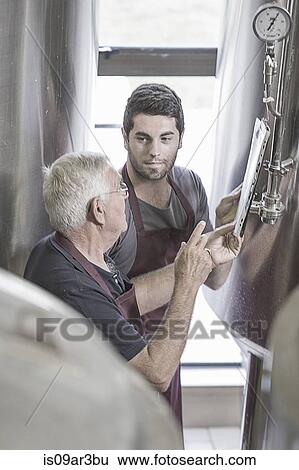 Brewers in brewery next to stainless steel tanks View Large Photo Image Stock Photograph - Brewers in brewery next to stainless steel tanks. Fotosearch