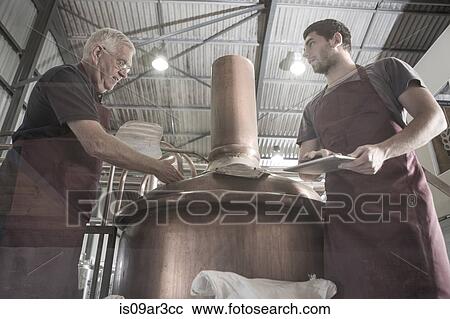 Brewers looking into brewing machine View Large Photo Image Stock Image - Brewers looking into brewing machine. Fotosearch