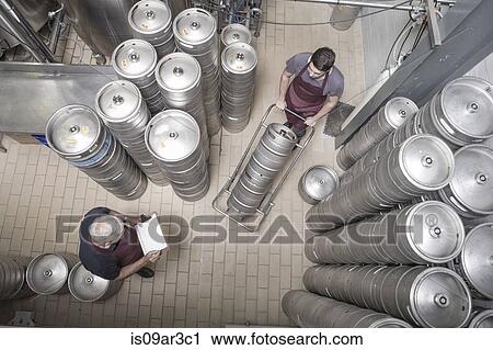 Brewers moving kegs in brewery View Large Photo Image Stock Image - Brewers moving kegs in brewery. Fotosearch