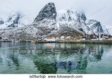 Stock Image - "Buildings and snowcapped mountains, Reine, Lofoten, Norway". Fotosearch