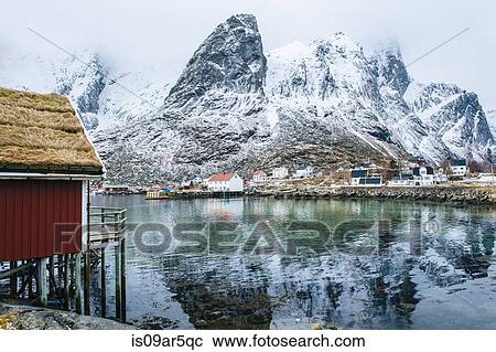 Stock Image - "Buildings and snowcapped mountains, Reine, Lofoten, Norway". Fotosearch